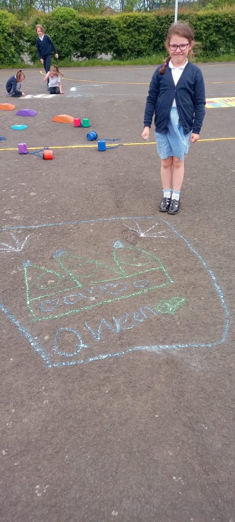 Some of the KS1 children creating images of the Queen with their chalks