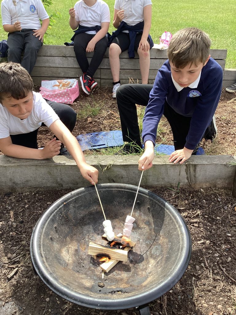 Science Club children enjoying marshmallows on the firepit