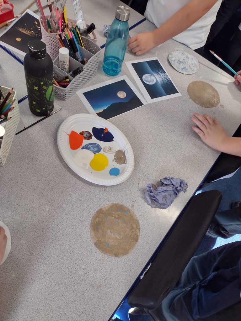 Year 5 children creating their paintings of the moon